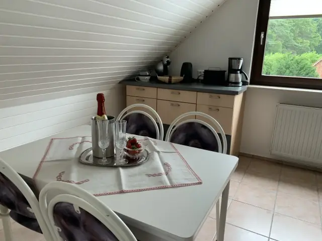 Essplatz mit weißem Tisch, Stühlen, Kaffeemaschine und Toaster