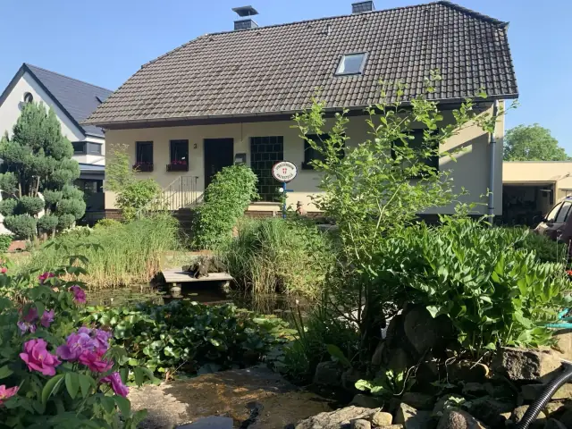 Gartenteich mit Seerosen vor dem Haus