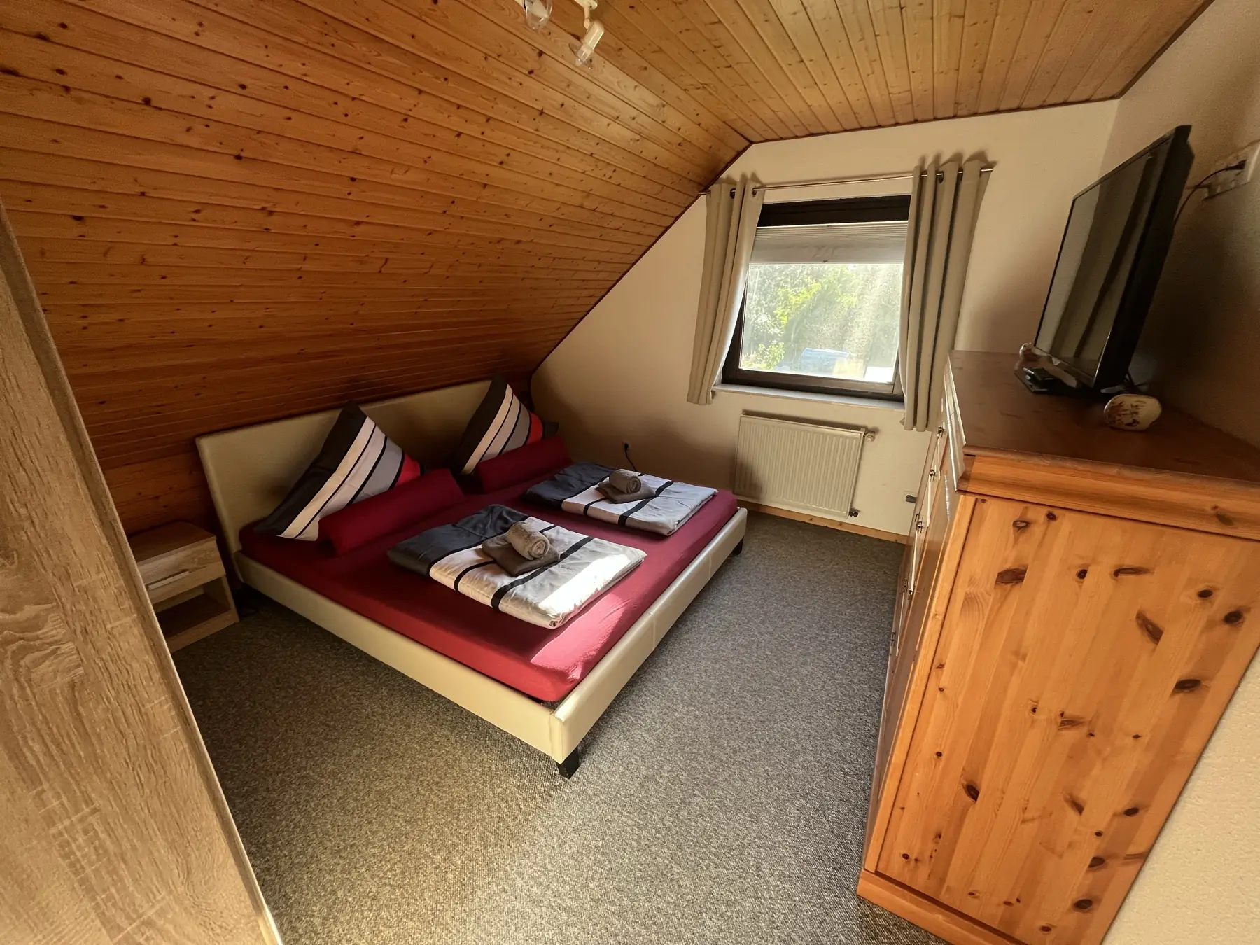 Schlafzimmer mit Doppelbett und Holzdecke